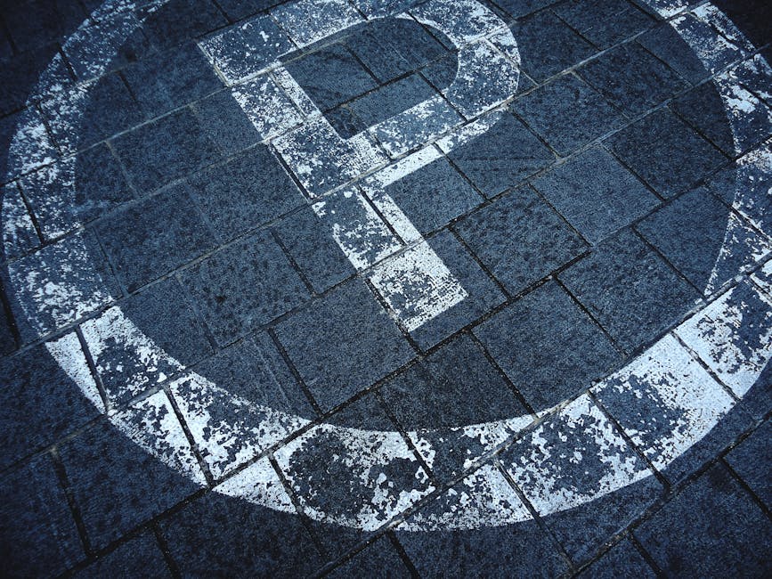 A person holding a small green cube with a yellow letter 'P' on its face, representing parking permits, against a plain blue background. This image relates to parking arrangements for house removals o